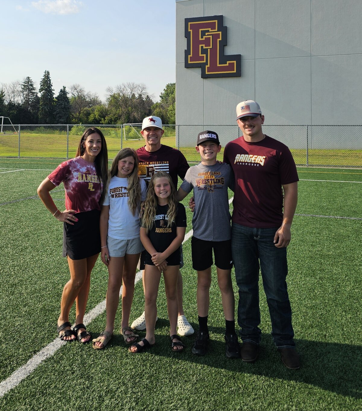 Sean Thomas with his wife Alyssa and their four children on the Forest Lake Rangers field
